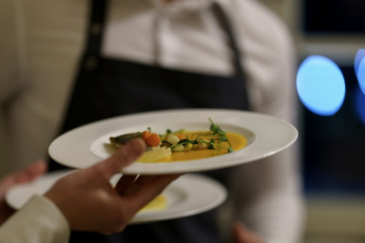 Waiter carrying two plated starters