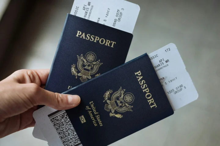 Hand holding two US passports with boarding passes