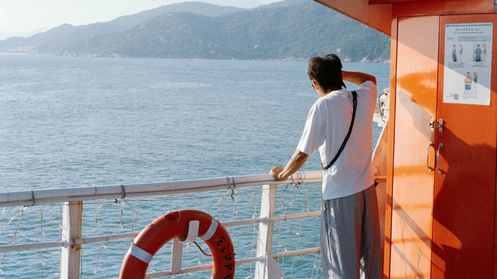 Traveler alone at the ship railing looking at the coast