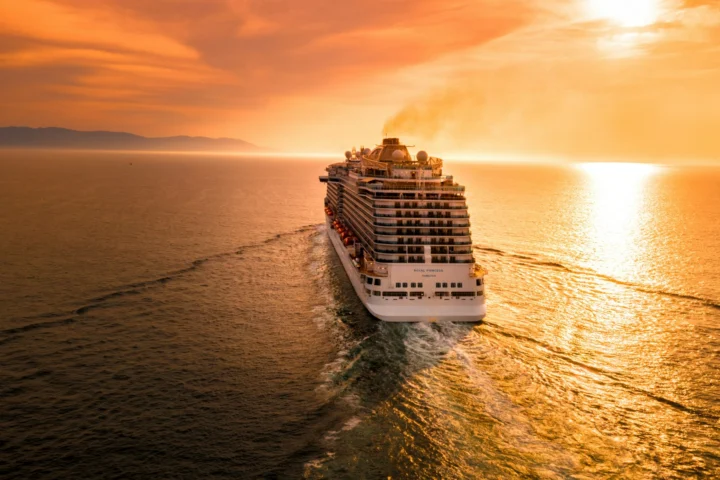 Cruise ship sailing toward a sunset