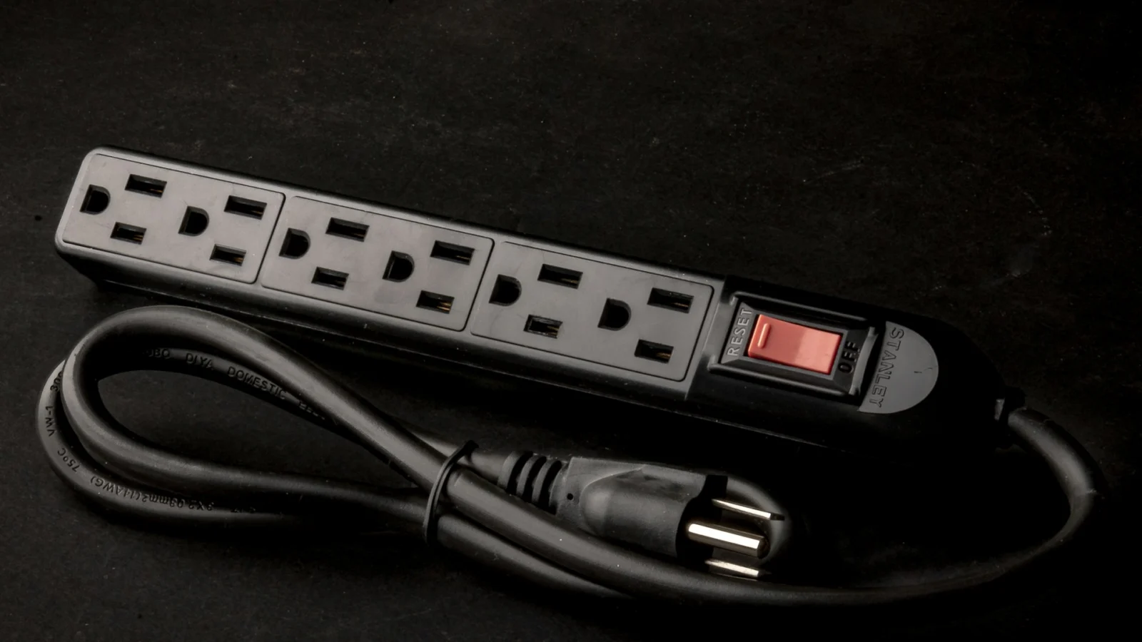Black six-outlet power strip with a switch and a coiled cord