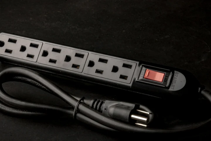 Black six-outlet power strip with a switch and a coiled cord