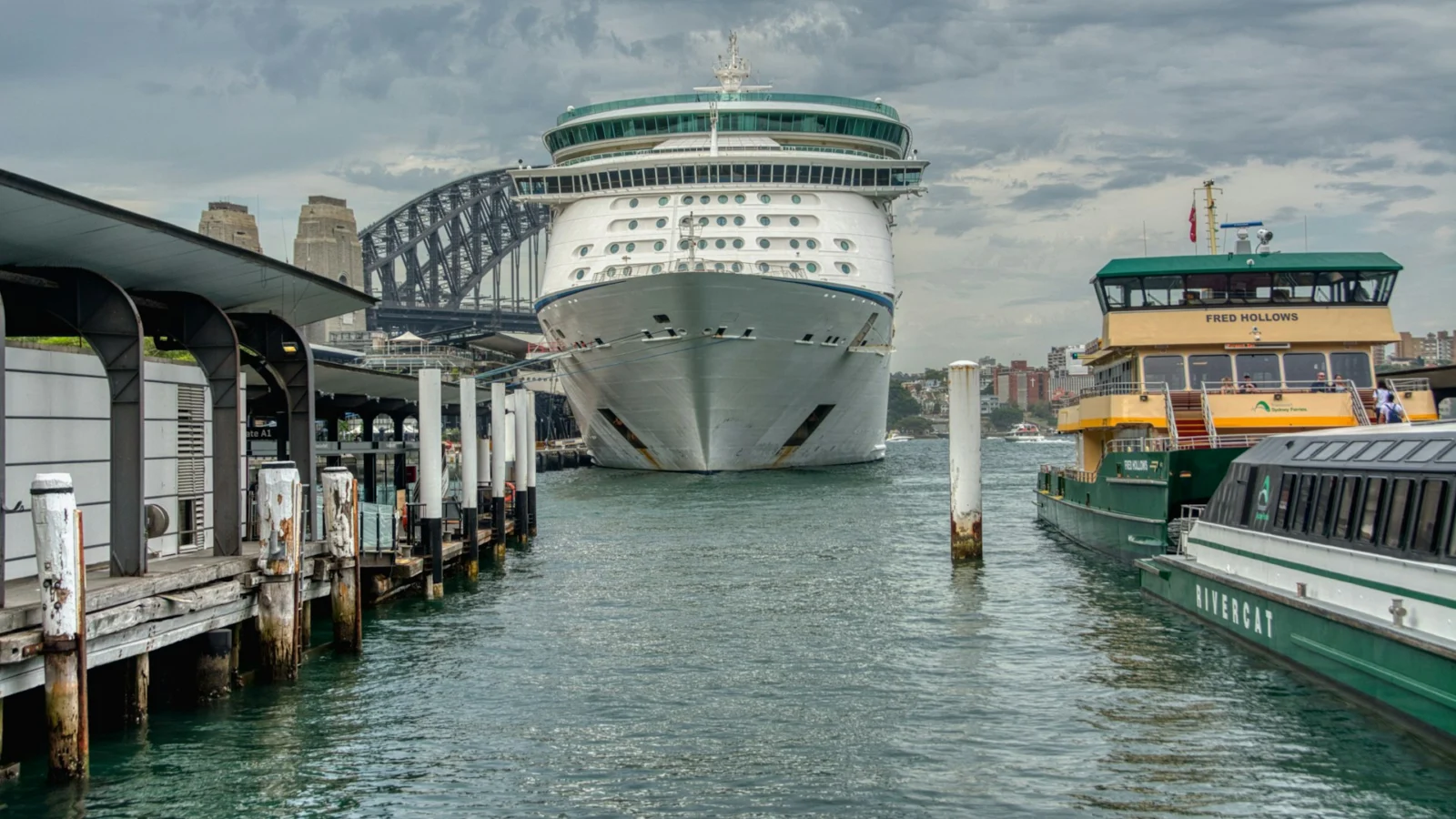 Cruise ship docked at Circular Quay in Sydney beside harbor ferries