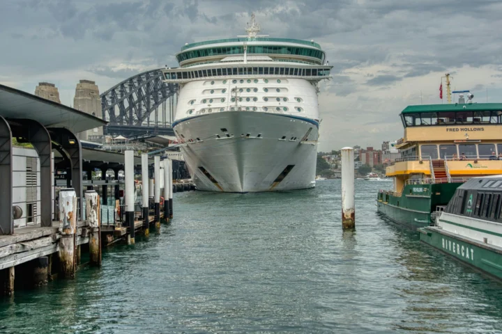 Cruise ship docked at Circular Quay in Sydney beside harbor ferries